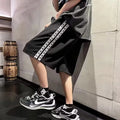 Men's black baggy track pants with loose-fit design and elastic waistband