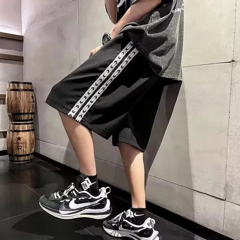 Men's black baggy track pants with loose-fit design and elastic waistband