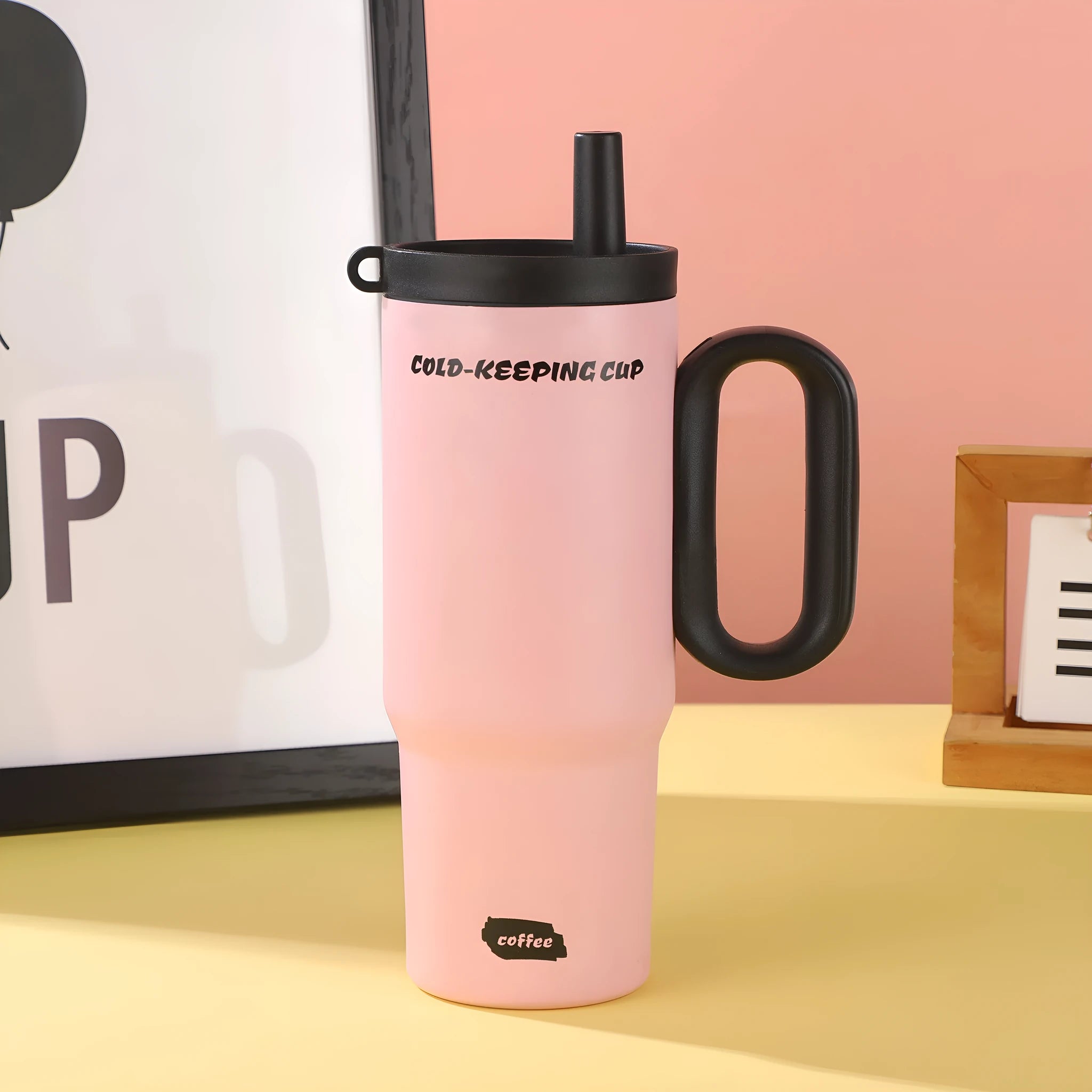 Insulated tumbler cup with a carrying handle and a straw, shown in one of five colour options.