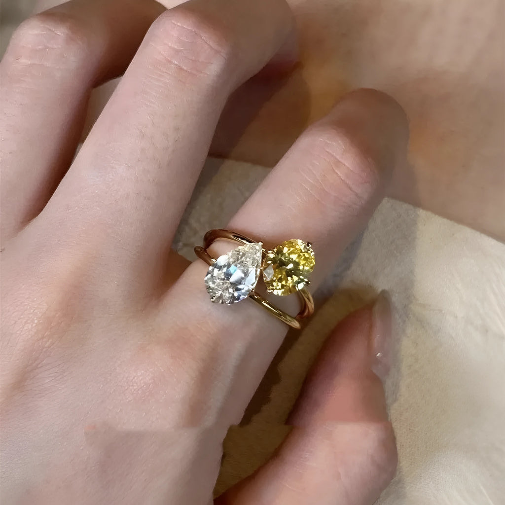 Geometric open copper ring for women with a water drop design set with contrasting zircon stones.