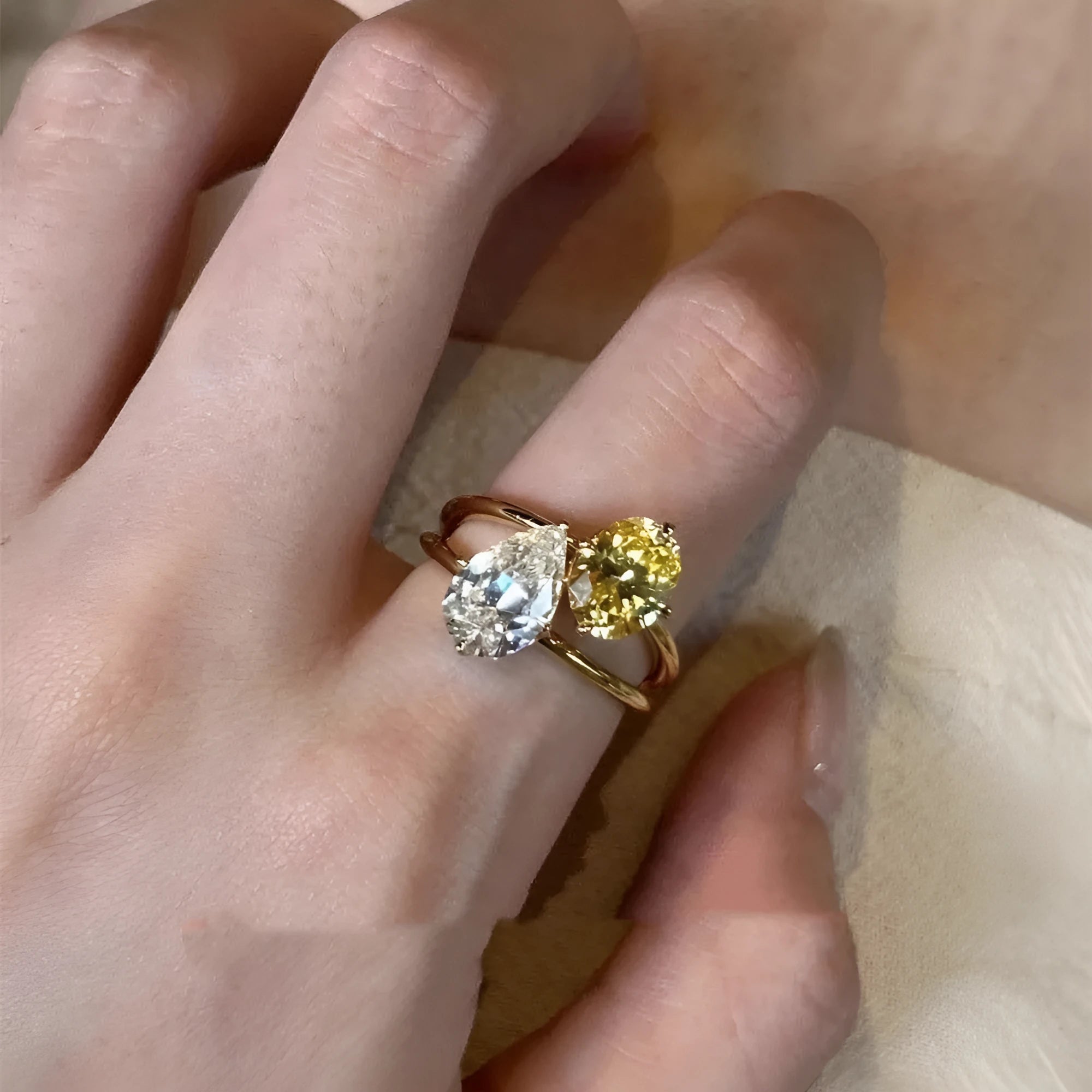 Geometric open copper ring for women with a water drop design set with contrasting zircon stones.