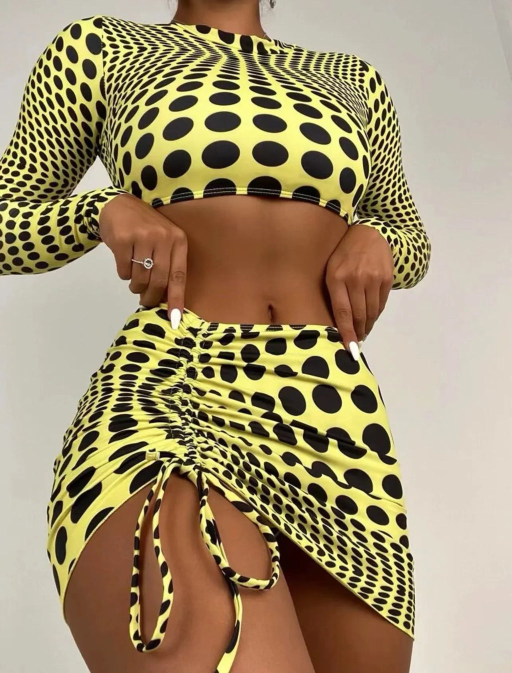 Green and yellow polka dot women's three-piece swimsuit set with bra, bikini top, and skirt.
