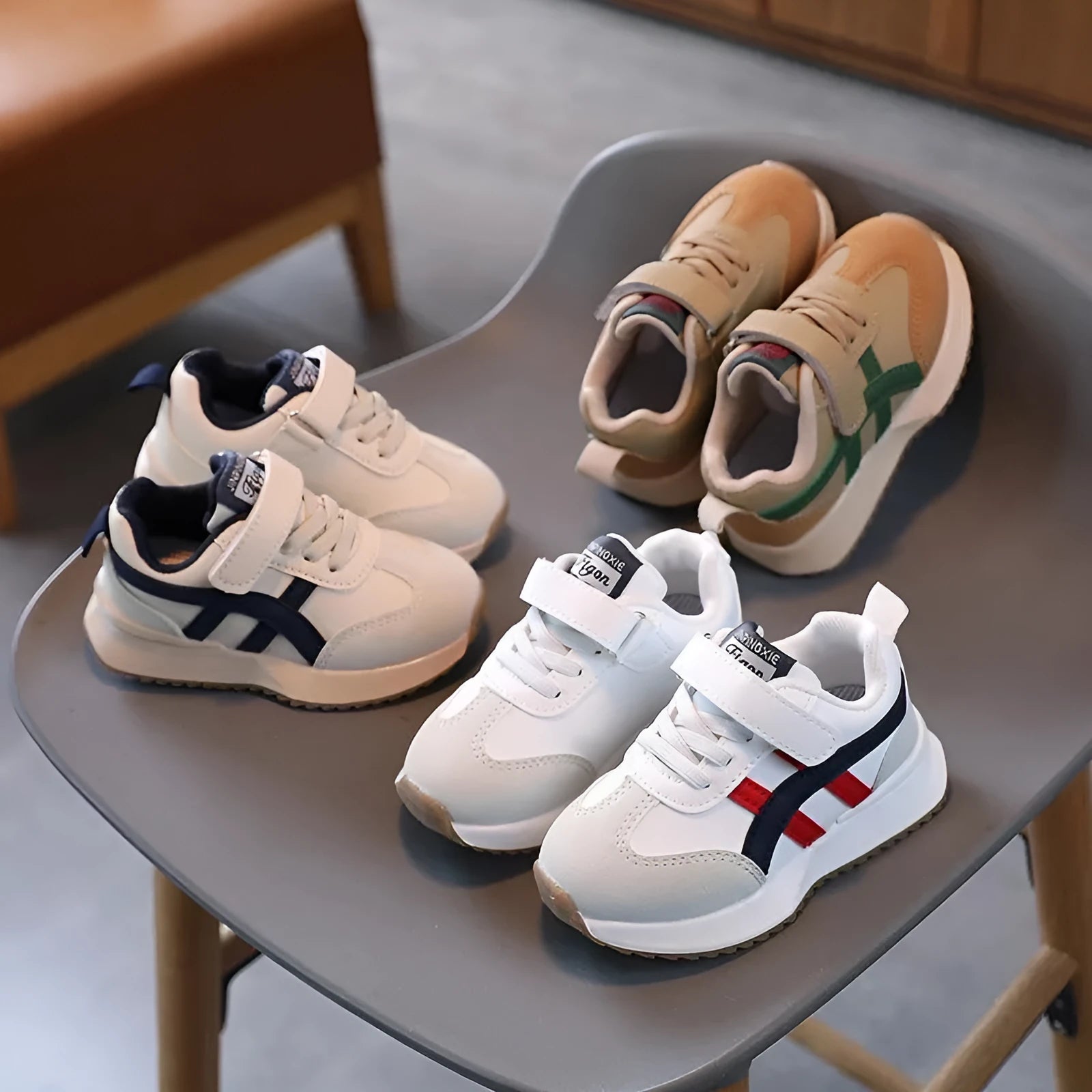 Children's solid-colour sneakers with Velcro strap in white, beige, or khaki on a rubber sole.