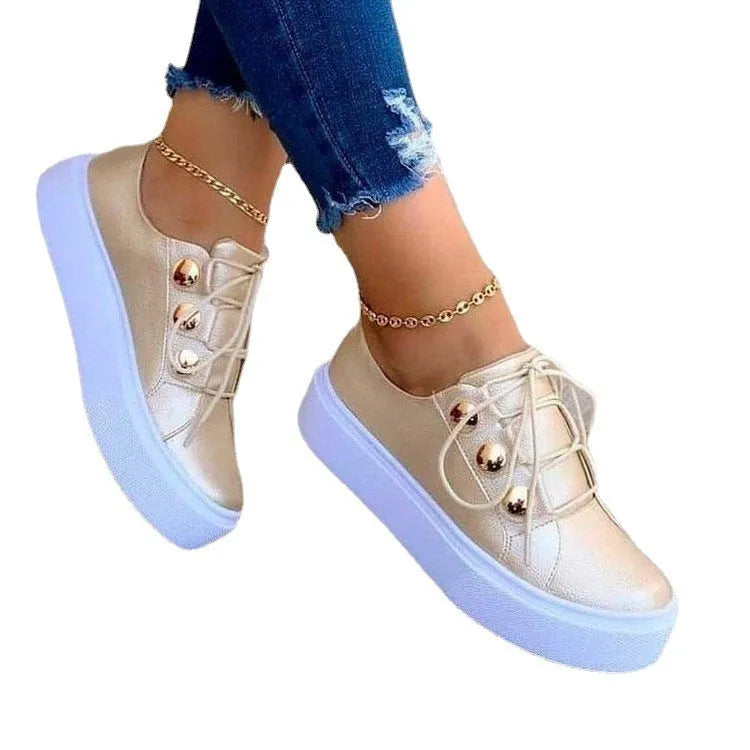 Women's white lace-up flats sneakers with decorative silver rivet details and round toe