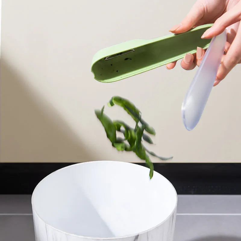 Dark green vegetable peeler with storage tube, showing stainless steel blade and non-slip handle.