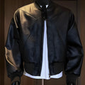Man wearing a black PU egg white leather jacket with an extended length and tight light business fit.