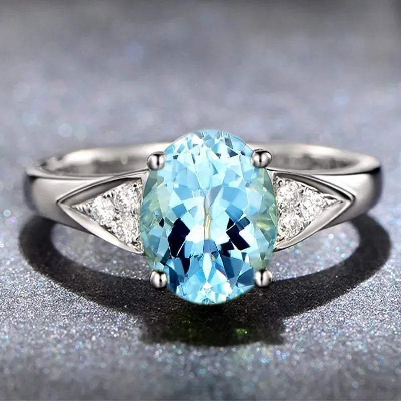 Women's zircon ring with inlaid red and blue stone on a court-style band.