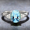 Women's zircon ring with inlaid red and blue stone on a court-style band.
