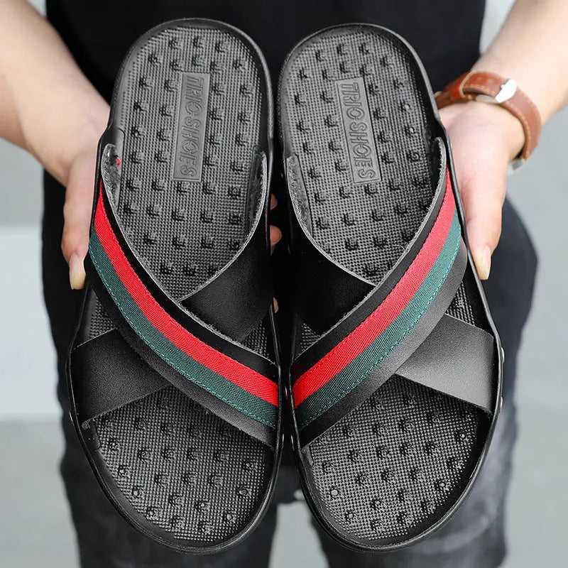 Men's white cowhide leather flip flops with a non-slip sole on a sandy beach.