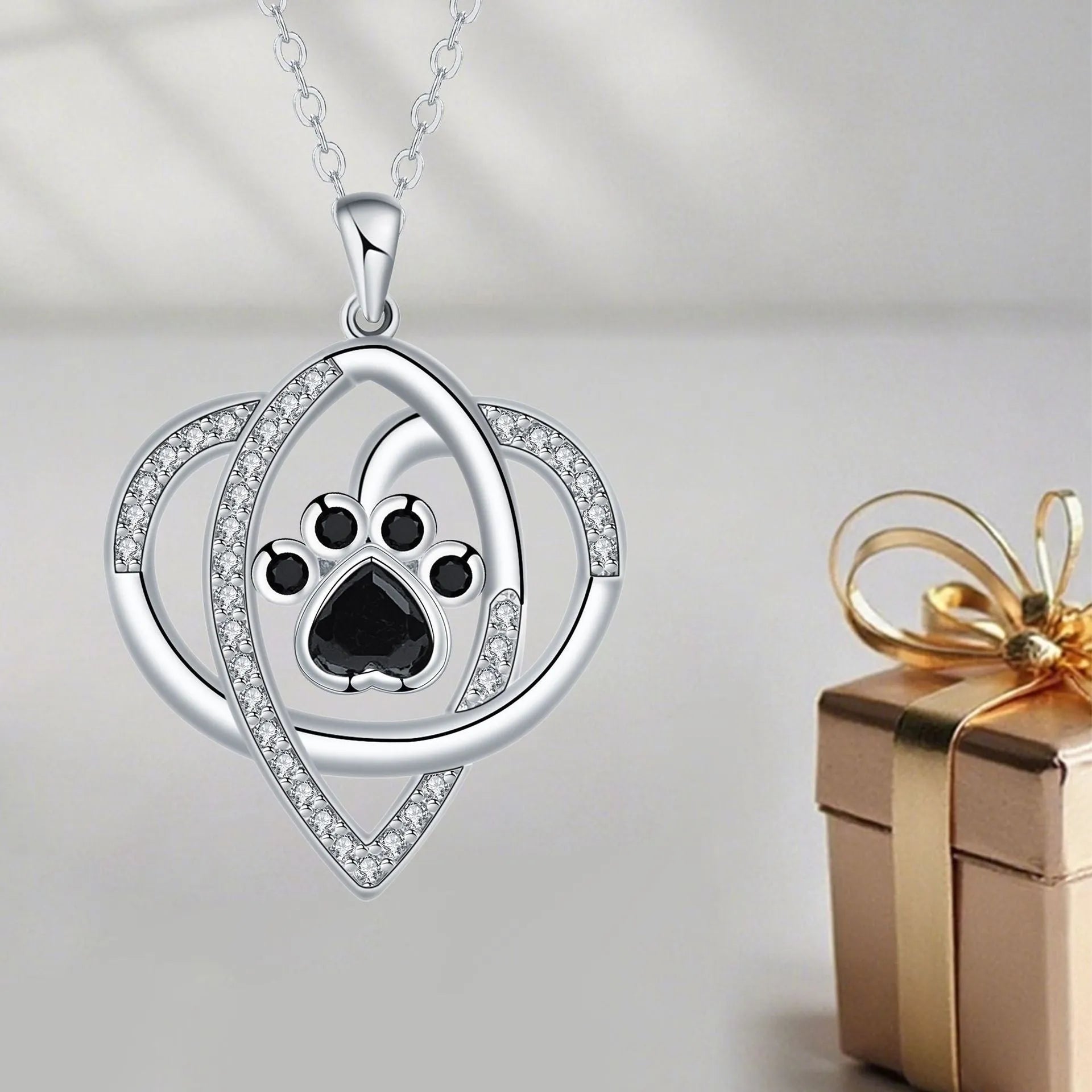 Copper necklace with dog paw and cat footprint pendant on a cross chain.