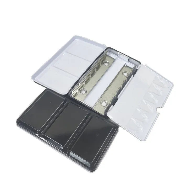 Tinplate metal empty paint box for solid watercolour pigments, shown closed.