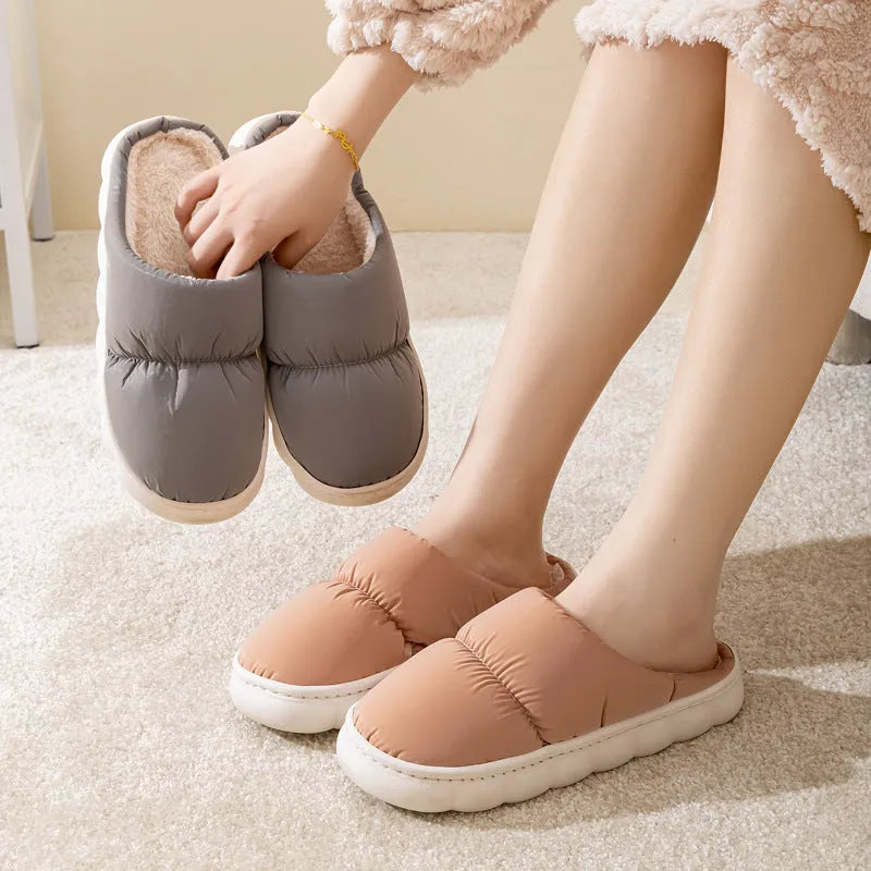Pair of down cotton winter slippers with artificial leather upper, plush lining, and thick rubber sole.