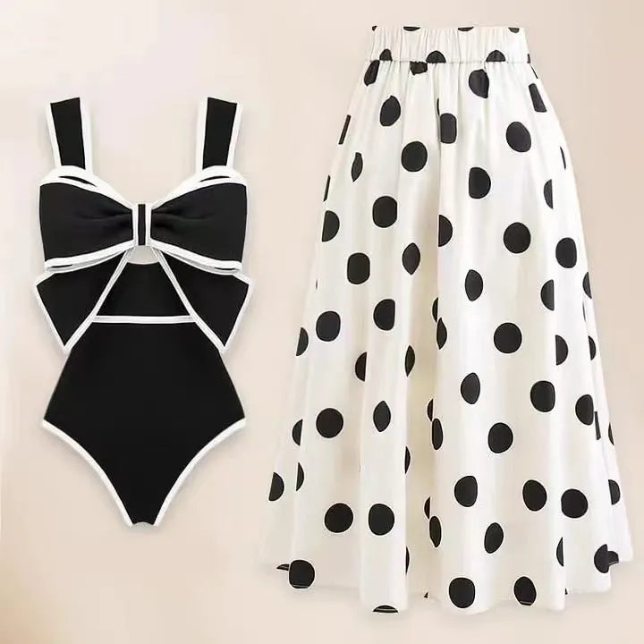 Women's black one-piece swimsuit with a white flared skirt and a central bow detail.