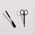 Black pet grooming brush with soft silicone bristles for eye cleaning and comb attachment for hair removal