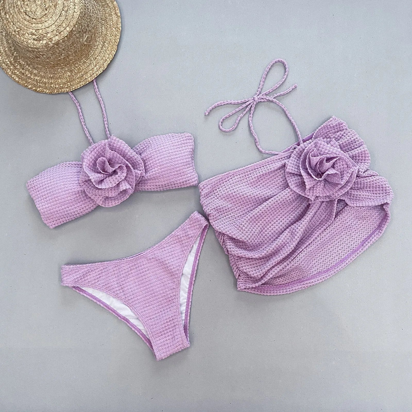 White women's three-piece bikini set with 3D flower split design on a mannequin.