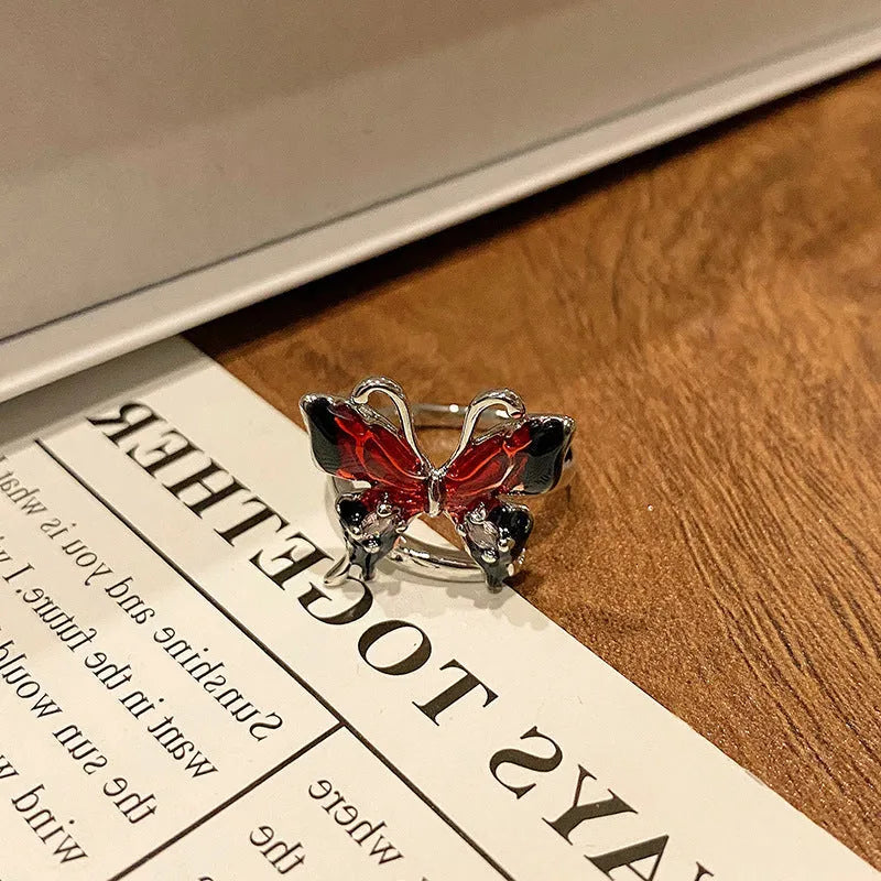 Copper butterfly ring with dripping oil finish, shown in an open loop style