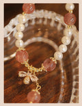 Women's strawberry quartz crystal bracelet with bow clasp closure on wrist