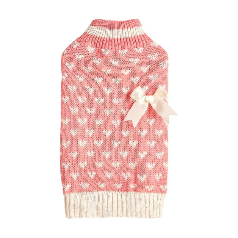 Red love heart design dog sweater on a small dog, showing pink bow detail.