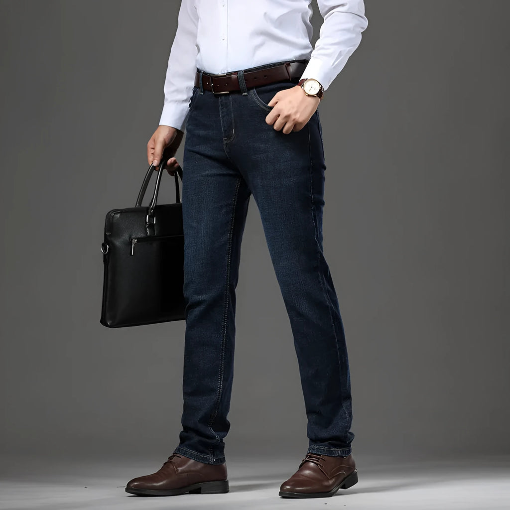 Men's black stretch denim jeans showing loose straight-leg fit with mid waist and zip fly detail
