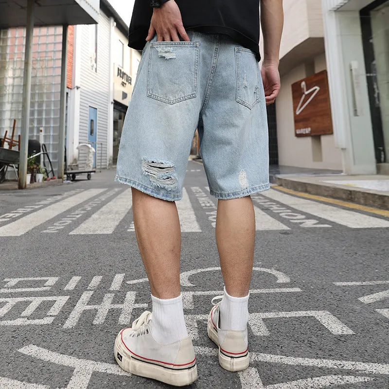 Light blue distressed denim shorts with ripped detailing and straight cut silhouette