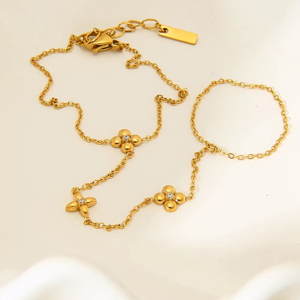 Gold-coloured stainless steel women's bracelet with eight-pointed star and floral charm design
