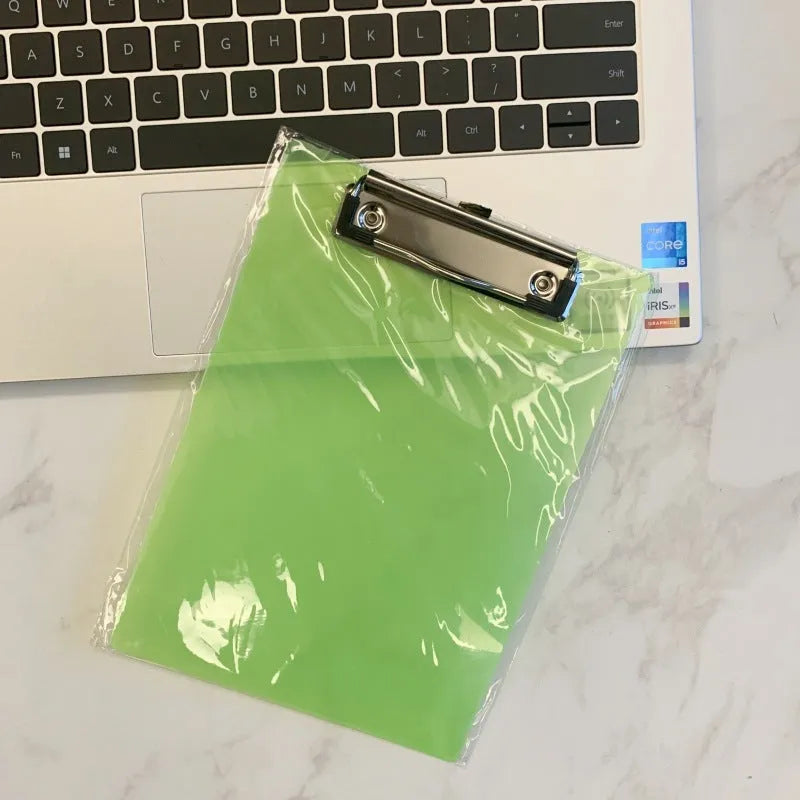Transparent A4 plate holder with metal clip in blue, holding white paper, on a wooden desk.