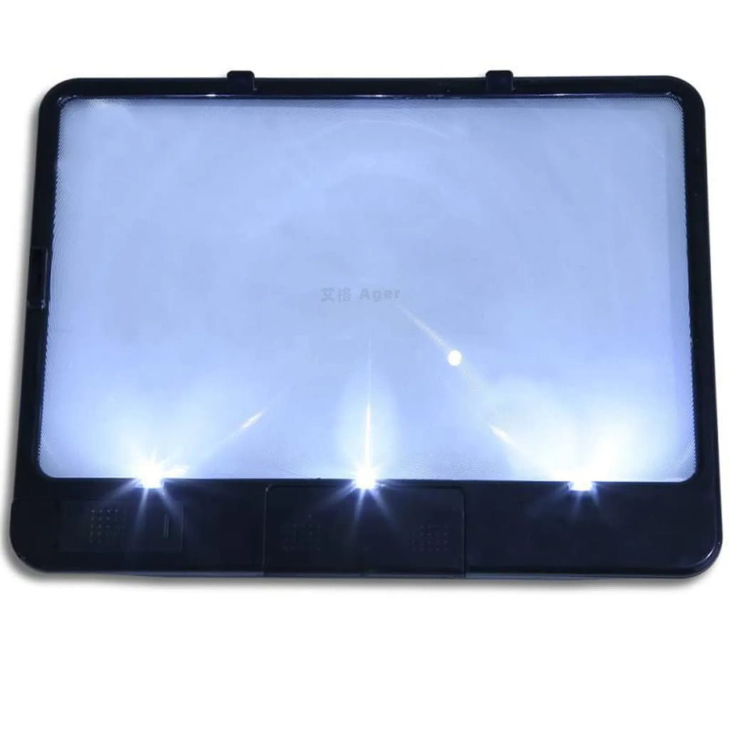 Black and white LED magnifying glass with 3x lens on a desktop next to a book.