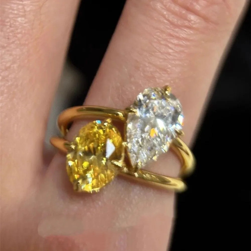 Geometric open copper ring for women with a water drop design set with contrasting zircon stones.