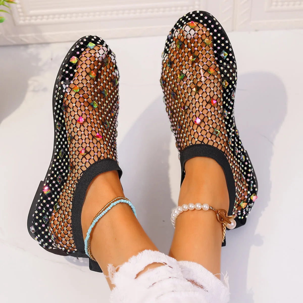 Colourful rhinestone detail on women's mesh flat sandals with round toe and rubber sole.