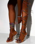Plus size black strappy sandals with rhinestone details and a square toe on a rubber sole.