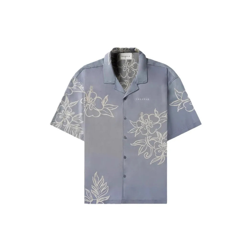 A man's loose-fit short sleeve printed top with a floral pattern, shown in a light colour on a hanger.