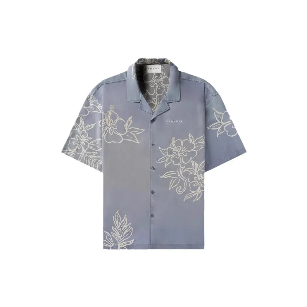 A man's loose-fit short sleeve printed top with a floral pattern, shown in a light colour on a hanger.