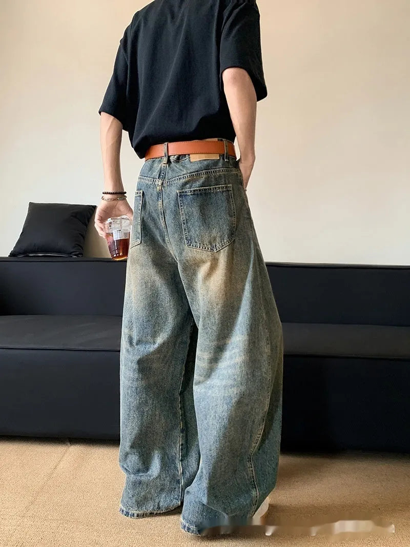 Retro blue distressed machete denim jeans for men with a wide-leg slim cut.