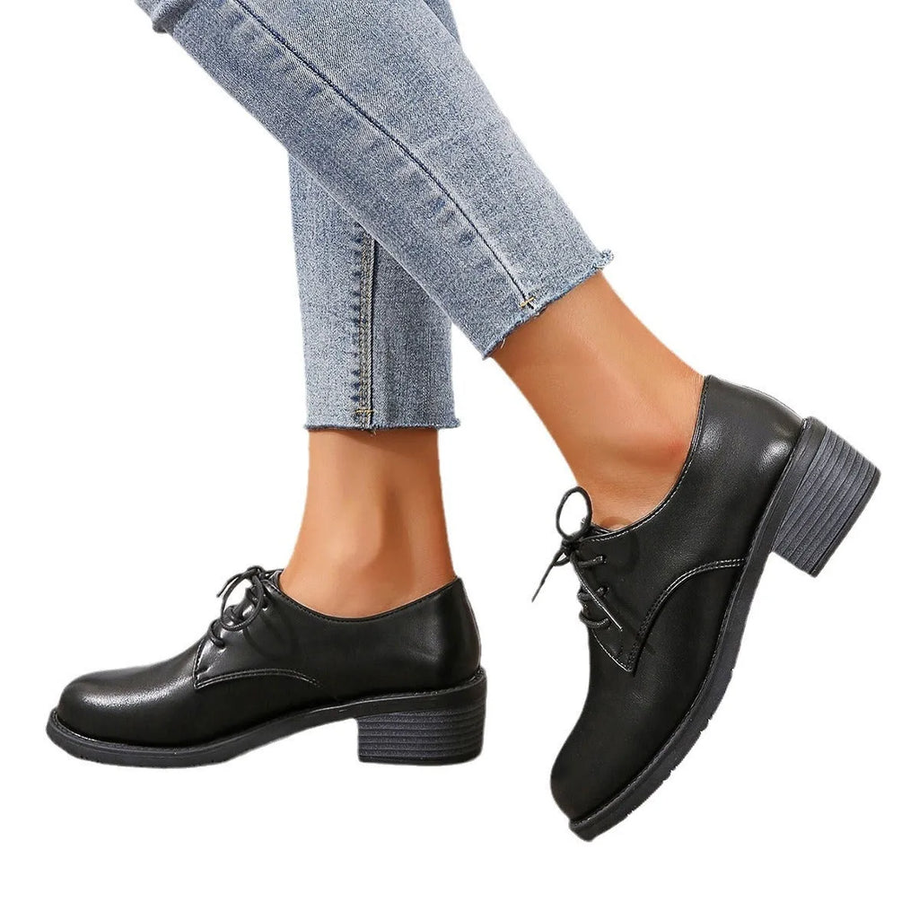 Black women's lace-up work shoes with a thick chunky heel and soft rubber sole.