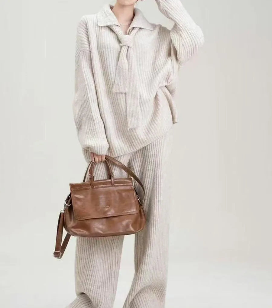 Beige acrylic imitation cashmere knitted top and trouser two-piece set on a hanger.