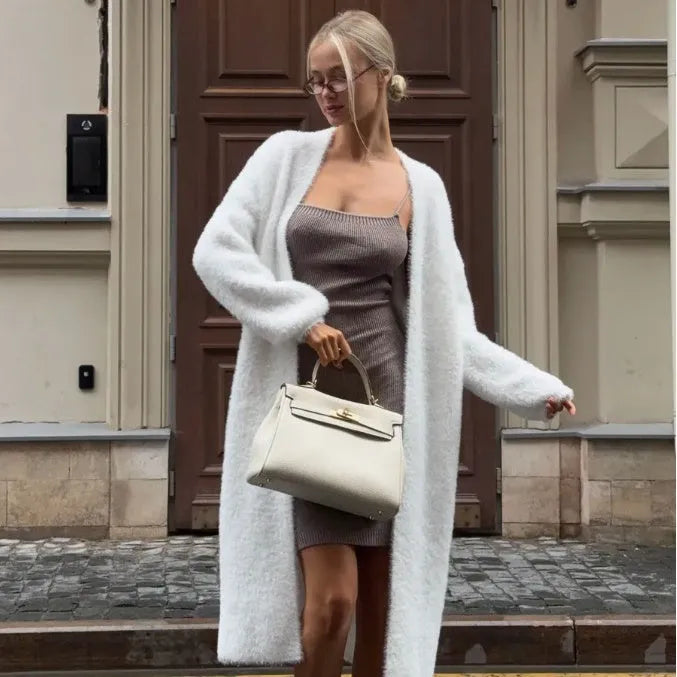 White long-line knit cardigan jacket on a hanger, showing loose fit and long sleeves.