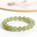 Polished Hetian Jade ball bracelet in clear water colour on a wrist, showing multiple bead sizes.