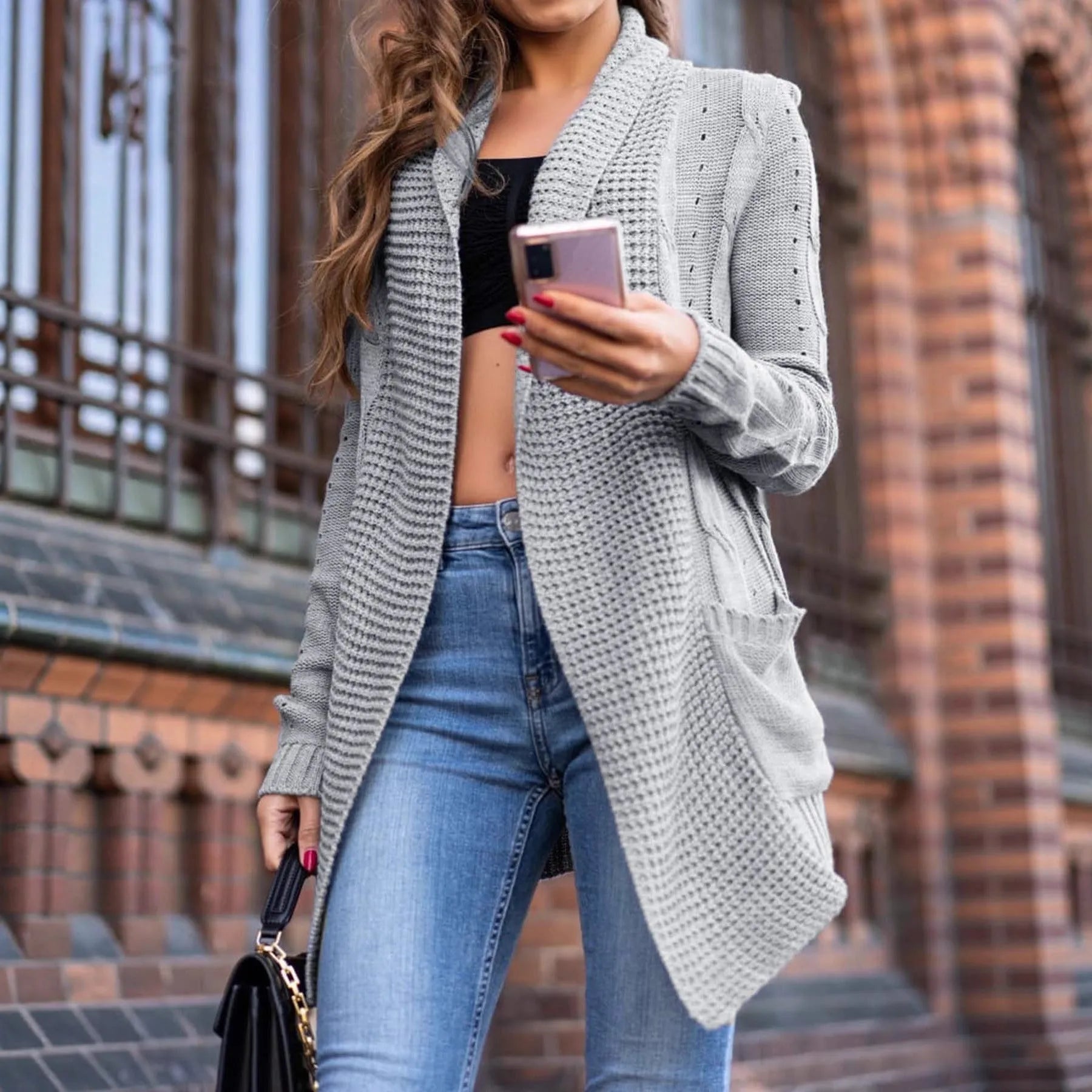 Grey loose fit women's cardigan sweater coat with front pockets on a hanger.