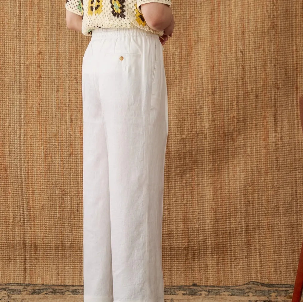 Navy blue linen straight-leg trousers with a high elasticated lace waistband on a hanger.