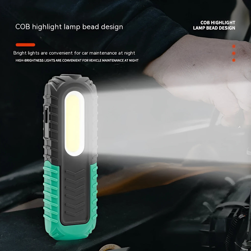 Black and green USB rechargeable automotive inspection work light on a workshop bench.