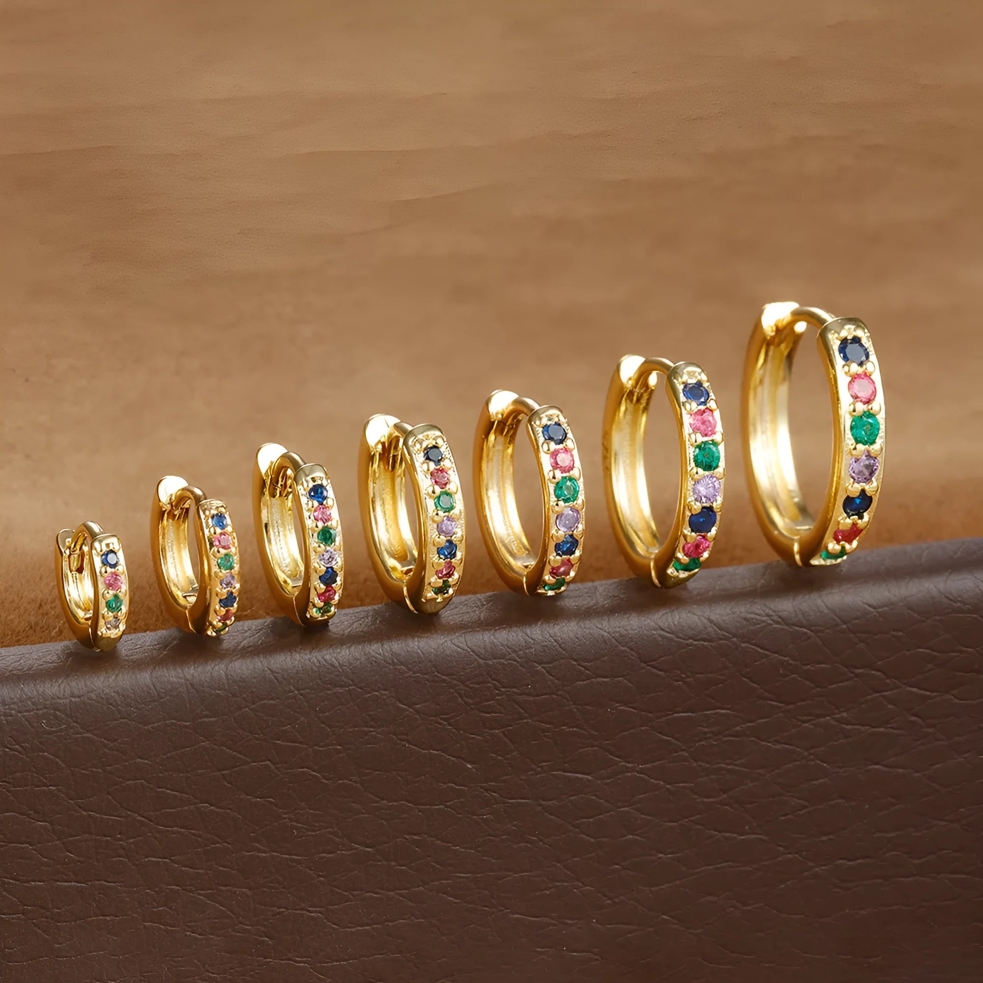 Round zircon geometric stud earrings in gold, rose gold, and silver colours on a white background.