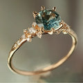 Gold geometric ring with a claw-set zircon stone and a chamfered square pattern design.