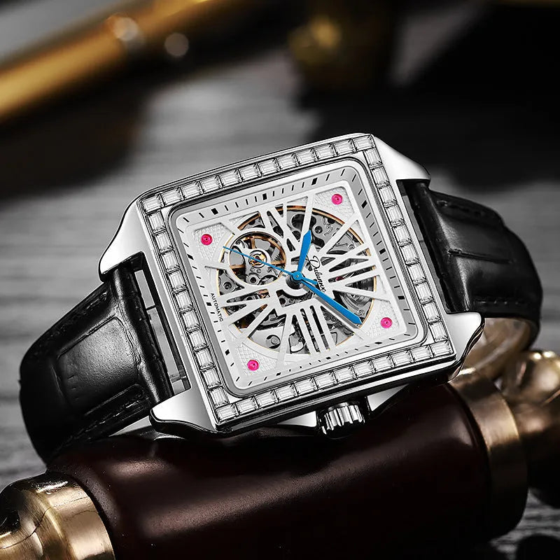 Men's square automatic watch with diamond-studded case on a black stainless steel bracelet.