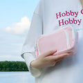 Double layer high-capacity pencil case in solid colour with gift handle, shown open to reveal two compartments.