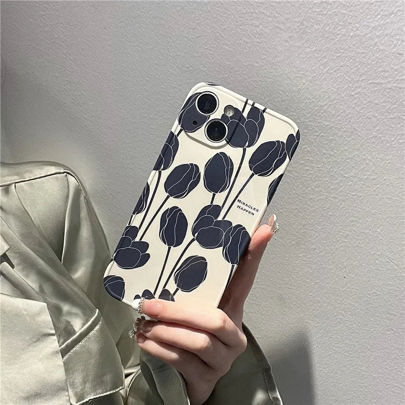 Black silicone iPhone case with a detailed white tulip pattern on the back.