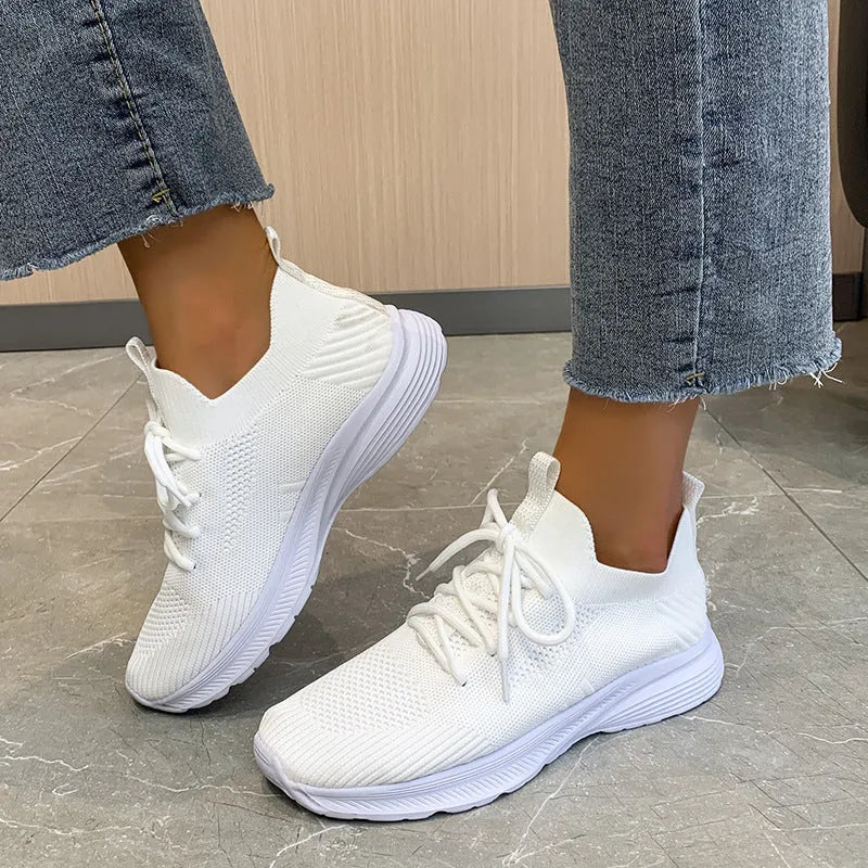 Women's mesh running shoes in creamy white with flat rubber sole and low-top design