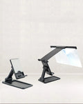 Black folding mobile phone screen amplifier with detachable phone holder on desktop