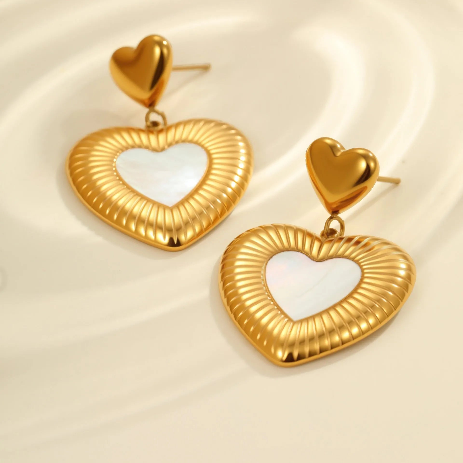 Heart shaped stainless steel earrings with white fritillary pattern and 18K gold electroplated finish