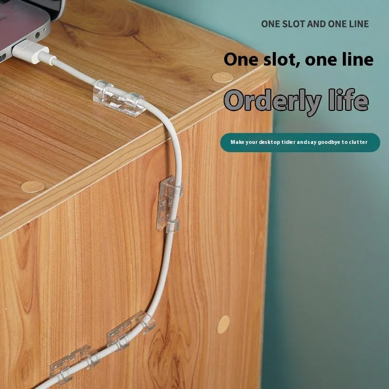 Transparent plastic self-adhesive cable clips for wire management on a desk.