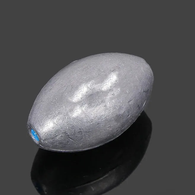 Close-up of a rugby-shaped olive lead fishing sinker with a Tongxin scale pattern texture.